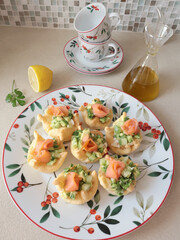 Pastry tartlet with cream cheese on plate. Appetizers made from cucumber, avocado, and salmon. Cooking at home. Mediterranean cuisine. 