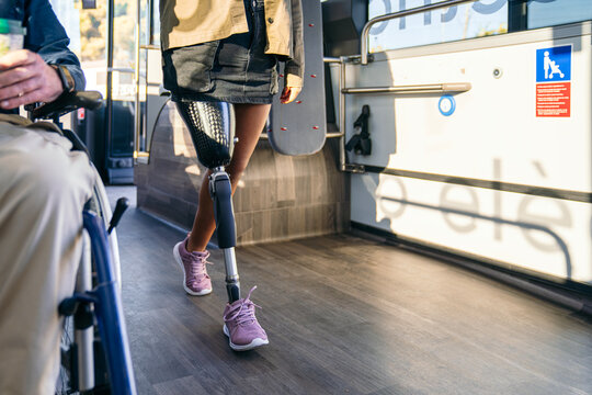 Young woman with prosthetic leg navigating a public bus, displaying independence and mobility within urban transport accessibility