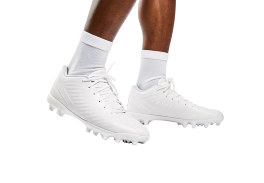 White mid-cut football cleats with aggressive tread pattern worn with white socks, isolated on a transparent background