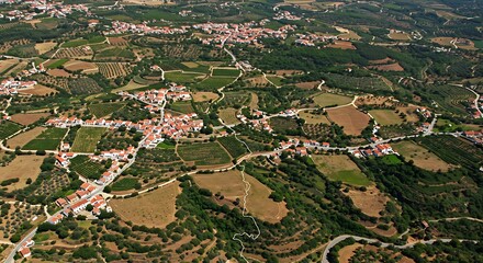 Aerial view showcases a charming European village nestled in a lush, rolling landscape