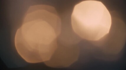 Warm golden polygonal light orbs create a dreamy and abstract bokeh effect against a dark background. - Powered by Adobe