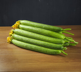 Fresh Long Luffa Gourds from Shouguang Shandong with Yellow Flowers on Wood Table