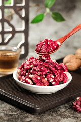 Red-skinned Xinjiang walnuts in bowl with wooden spoon, premium Chinese nuts healthy snack food photography