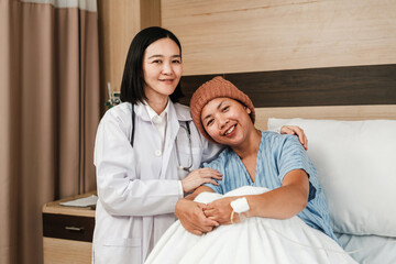 Doctor comforting a hospitalized patient who smiles while resting in bed, showing supportive, compassionate healthcare in a clinical room.
