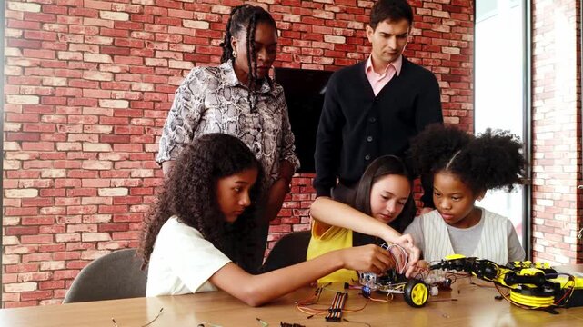 Happy kids celebrate success in a robotics classroom, high-fiving their teacher after completing a STEM coding project. Diverse group with teamwork and innovation spirit in educational tech learning.