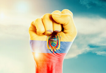 Ecuador national flag fist raise in the sky. The hand with flag raise in beautiful soft sky. Ecuador national national flag for independence day.