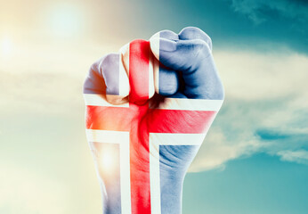 Iceland national flag fist raise in the sky. The hand with flag raise in beautiful soft sky. Iceland national flag for independence day.