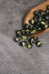Roasted Black Beans with Salt and Spices in Wooden Bowl on Gray Stone Surface