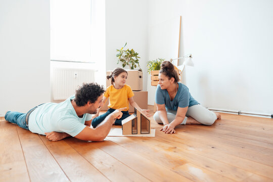 Family with model house on floor at home