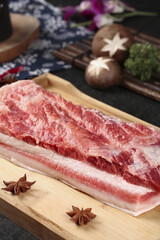 Raw Pork Belly Slices on Cutting Board with Asian Cooking Ingredients and Vegetables