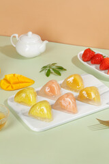 Heart-shaped crystal rice dumplings with sweet filling and fresh fruit dessert arrangement