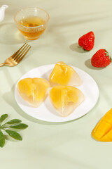 Heart-shaped crystal rice dumplings with sweet golden filling and fresh fruit dessert presentation