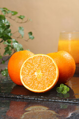 Fresh Navel Oranges with Orange Juice and Mint on Rustic Wooden Table