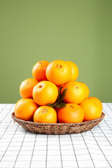 Fresh Sweet Orange Citrus Fruits in Wicker Basket on Checkered Surface