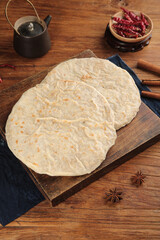 Traditional Asian Flatbread with Spices on Rustic Wooden Board - Homemade Bread Cooking Preparation
