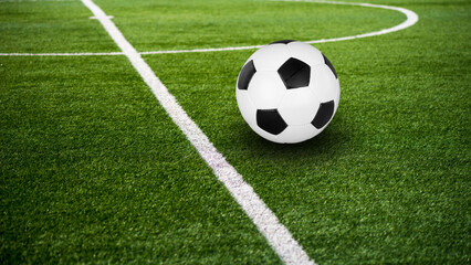 Classic black-and-white football on green pitch — high-resolution soccer ball close-up on artificial turf near white line for sports advertising and editorial use