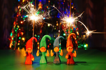 Figures of colorful dwarfs made of plasticine and sparklers.