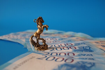 A statuette of a horse and Russian banknotes on a blue background.