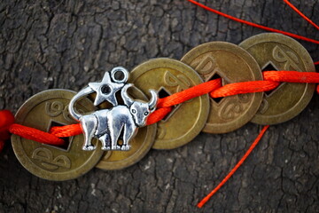 A Chinese feng Shui coin and a metal bull figurine.