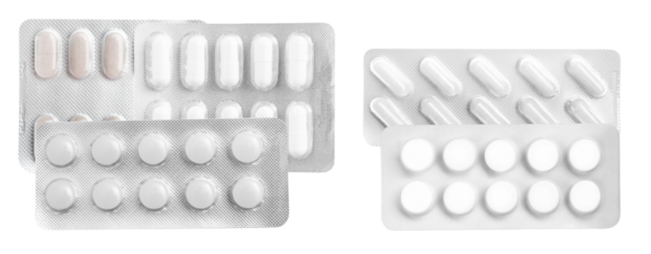 overlapping arrangement of various white and light-colored pharmaceutical tablets and capsules secured inside protective silver foil blister packaging, isolated on black.