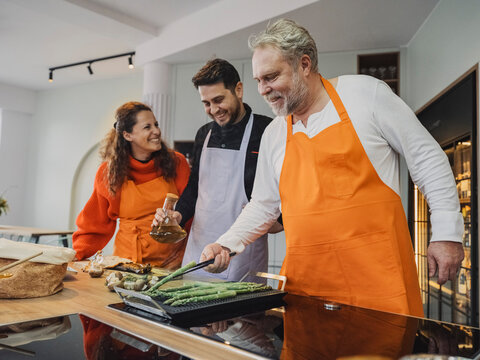 Friends cooking together in a kitchen during a cooking class