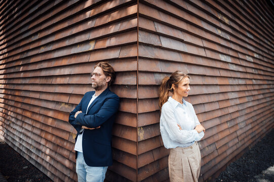 Business colleagues taking a break outdoors near modern building wall