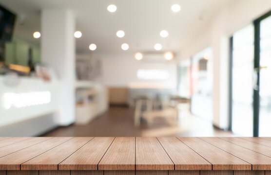 Empty wooden table top with lights bokeh on blur restaurant background.