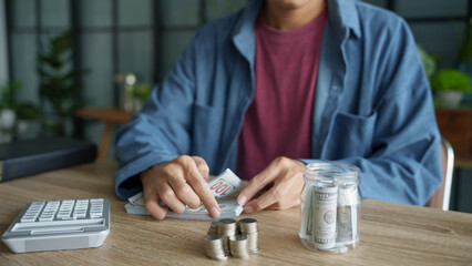 Man planning finances Count banknotes and coinsใ