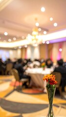 Blurred banquet hall with diners, table setting, & orange flowers