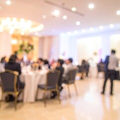 Blurred party guests at tables in a bright, white room