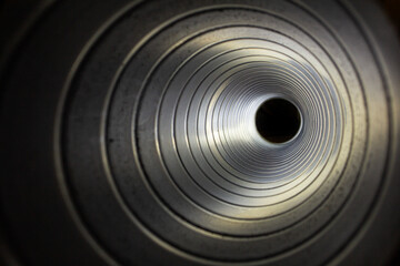 closeup view from inside the galvanized steel air duct on the exhaust fan in the background light, the front and back background is blurred with a bokeh effect