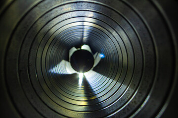 closeup view from inside the galvanized steel air duct on the exhaust fan in the background light, the front and back background is blurred with a bokeh effect