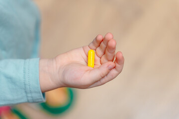 Little child girl holds a pill addict in her hand