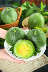 Fresh Shandong Green Melons on White Plate with Cut Half Showing Interior - Asian Fruit Display