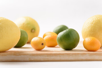 Fresh lemon, lime and kumquat on white background