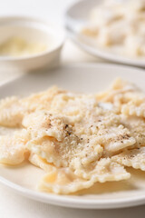 Farfalle pasta with white cream cheese sauce and black pepper, Italian food on a white plate