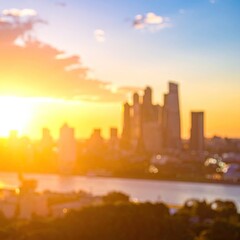 Blurry cityscape silhouetted against vibrant sunset sky