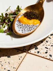Luxurious Amuse-Bouche: Caviar and Mango on a Chia Pudding Spoonful.