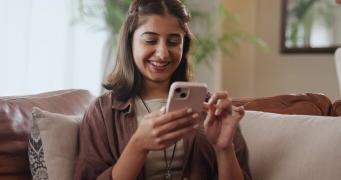 Indian woman, cellphone and laughing on home sofa for funny social media post, meme or humor. Female person, smartphone and digital app or internet search with texting message, streaming or apartment