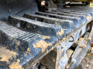 Close-up of muddy bulldozer tracks in construction site detail
