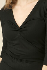 Serie of studio photos of young female model in black V-neck midi dress