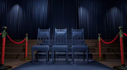 grey carpet leading to a three chairs in a dark stage