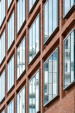 Close composition of a modern facade where geometry and pattern interact with reflection and structure, showing minimal detail and texture through architectural design