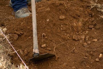 A farmer working the land with a traditional tool, Farm Work