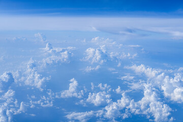 Fototapeta premium Endless layers of soft white clouds stretch across a clear blue sky, captured from above to convey calm atmosphere, vast open space, and the quiet beauty of high altitude flight.