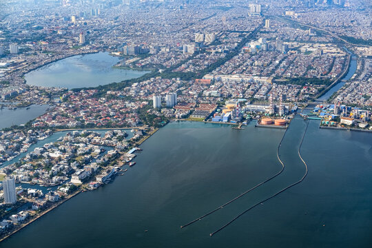 Dense northern Jakarta coastline seen from above, showing rapid urban expansion along the shore as rising sea levels and climate risks threaten low lying districts and future city resilience.