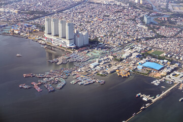 Dense northern Jakarta coastline seen from above, showing rapid urban expansion along the shore as rising sea levels and climate risks threaten low lying districts and future city resilience.