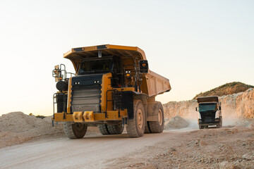 Large mining dump truck standing on a dusty quarry road surrounded by rocky terrain © Maria Vitkovska