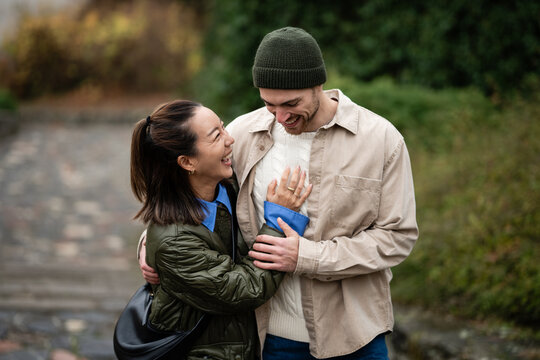 Happy diverse couple laughing embracing outdoors