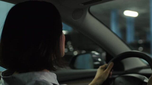 Woman Driving in Dark Parking Lot Searching for Parking Spot